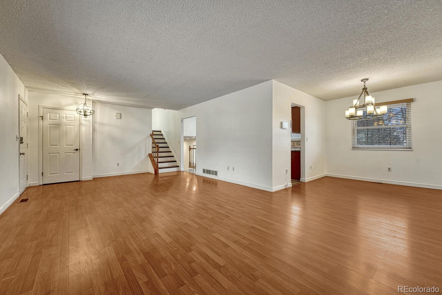 2079 South Quintero Street Aurora, CO 80013 - Photo 8 of 37 an empty room with wooden floor and windows
