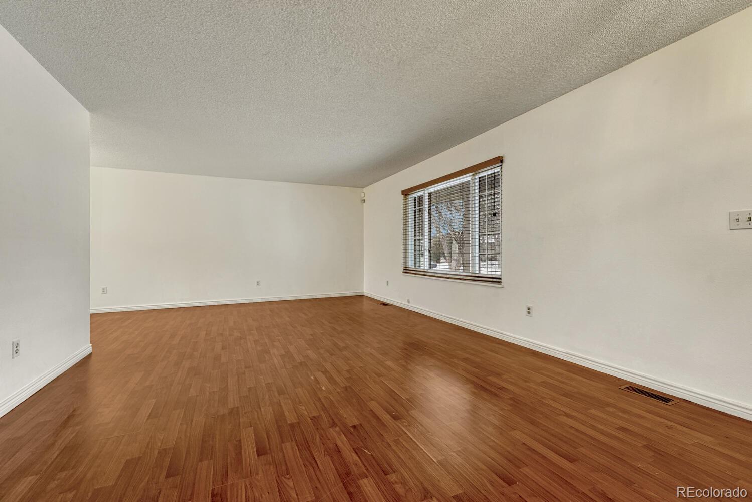 2079 South Quintero Street Aurora, CO 80013 - Photo 9 of 37 a view of an empty room with wooden floor and a window