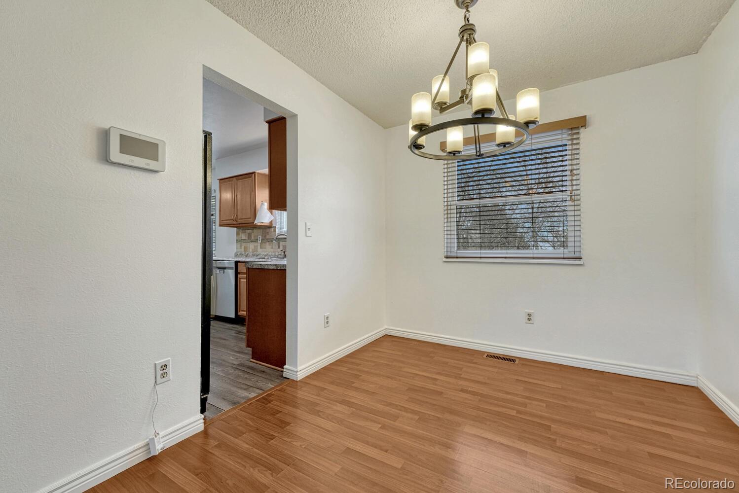 2079 South Quintero Street Aurora, CO 80013 - Photo 10 of 37 a view of empty room with wooden floor and window