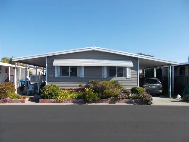 a front view of a house with a yard and outdoor seating