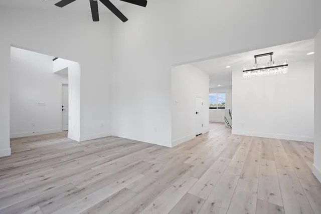 a view of an empty room with wooden floor and window