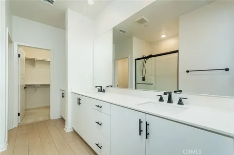 a bathroom with a double vanity sink mirror and shower