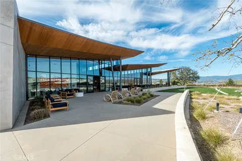 a view of a backyard with couches under an umbrella