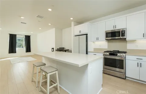 a kitchen with stainless steel appliances a stove a sink a microwave and cabinets