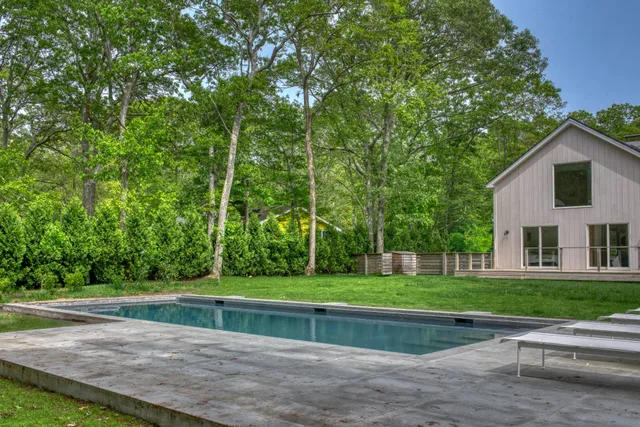 a view of a house with a big yard and large trees