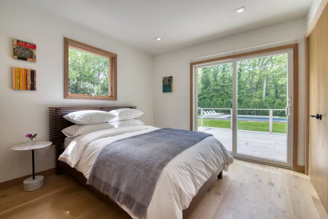 a bed sitting in a bedroom next to a window