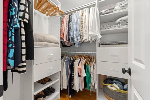 a view of walk in closet with clothes and shoes