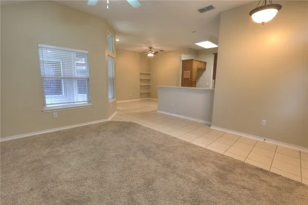 an empty room with a bathroom and mirror