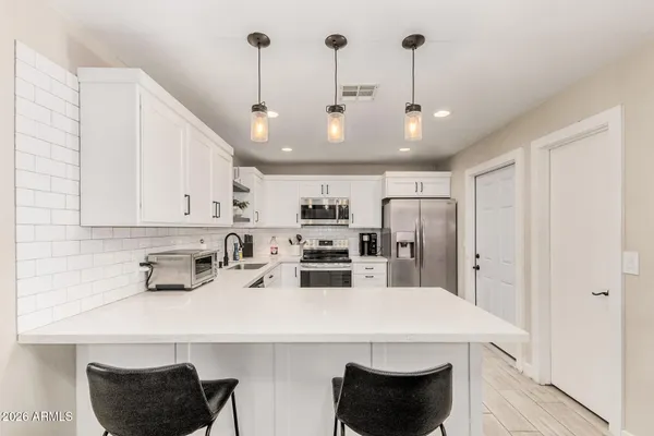 a kitchen with stainless steel appliances kitchen island granite countertop a sink a refrigerator and a stove