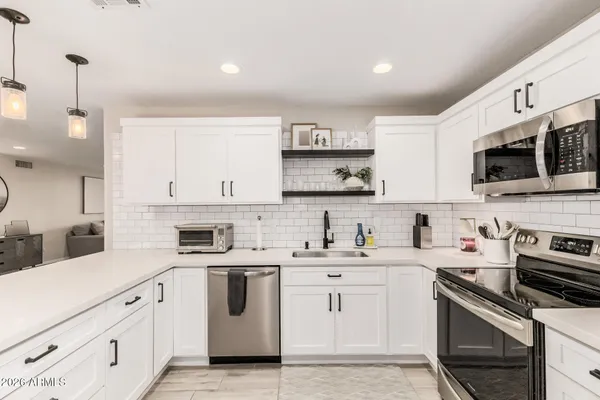 a kitchen with white cabinets stainless steel appliances and sink