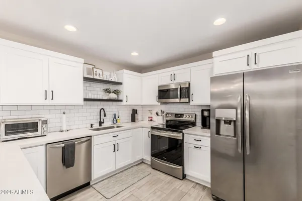 a kitchen with stainless steel appliances a sink cabinets and a refrigerator