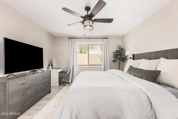a bedroom with a large bed and a flat screen tv on dresser