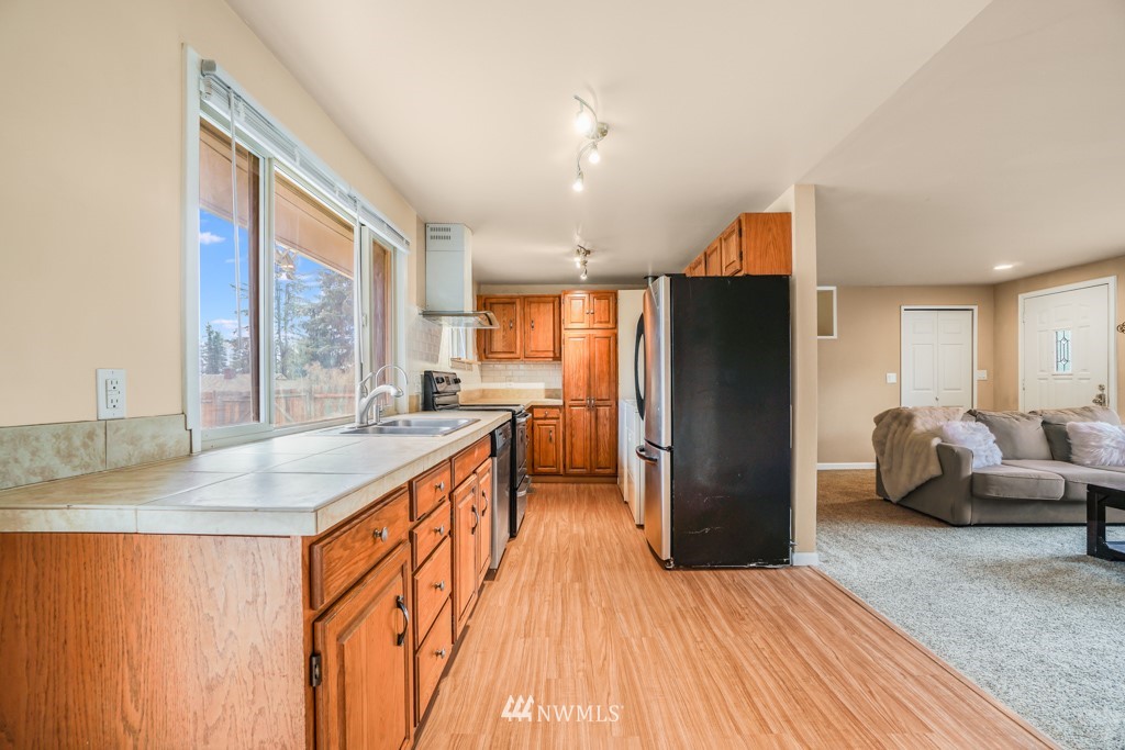 3601 Northeast 9th Street Renton, WA 98056 - Photo 10 of 23 a kitchen with stainless steel appliances granite countertop a refrigerator a sink and a stove with wooden floor