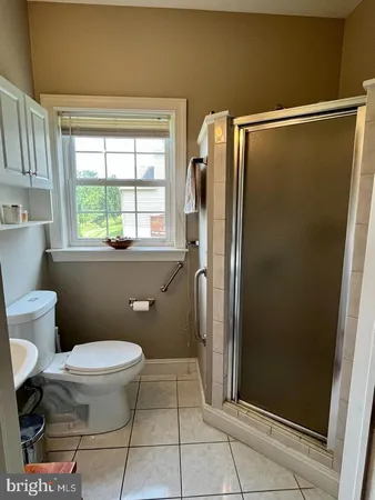 a bathroom with a granite countertop window a toilet and a shower