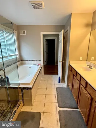 a bathroom with a tub sink and mirror
