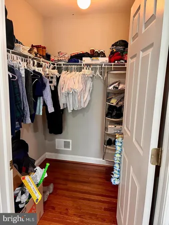 a view of walk in closet with clothes and shoes