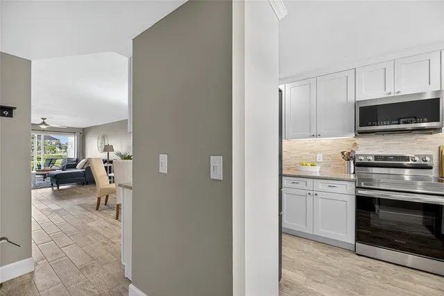 a living room with furniture a flat screen tv and a large window