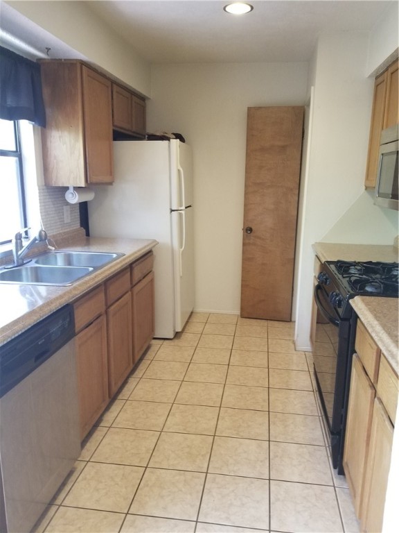 6614 Hart Lane, Unit B Austin, TX 78731 - Photo 3 of 6 a kitchen with a sink a refrigerator and a stove top oven