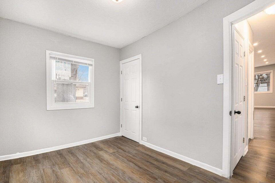 5207 West 4th Place Gary, IN 46406 - Photo 8 of 15 a view of an empty room with wooden floor and a window