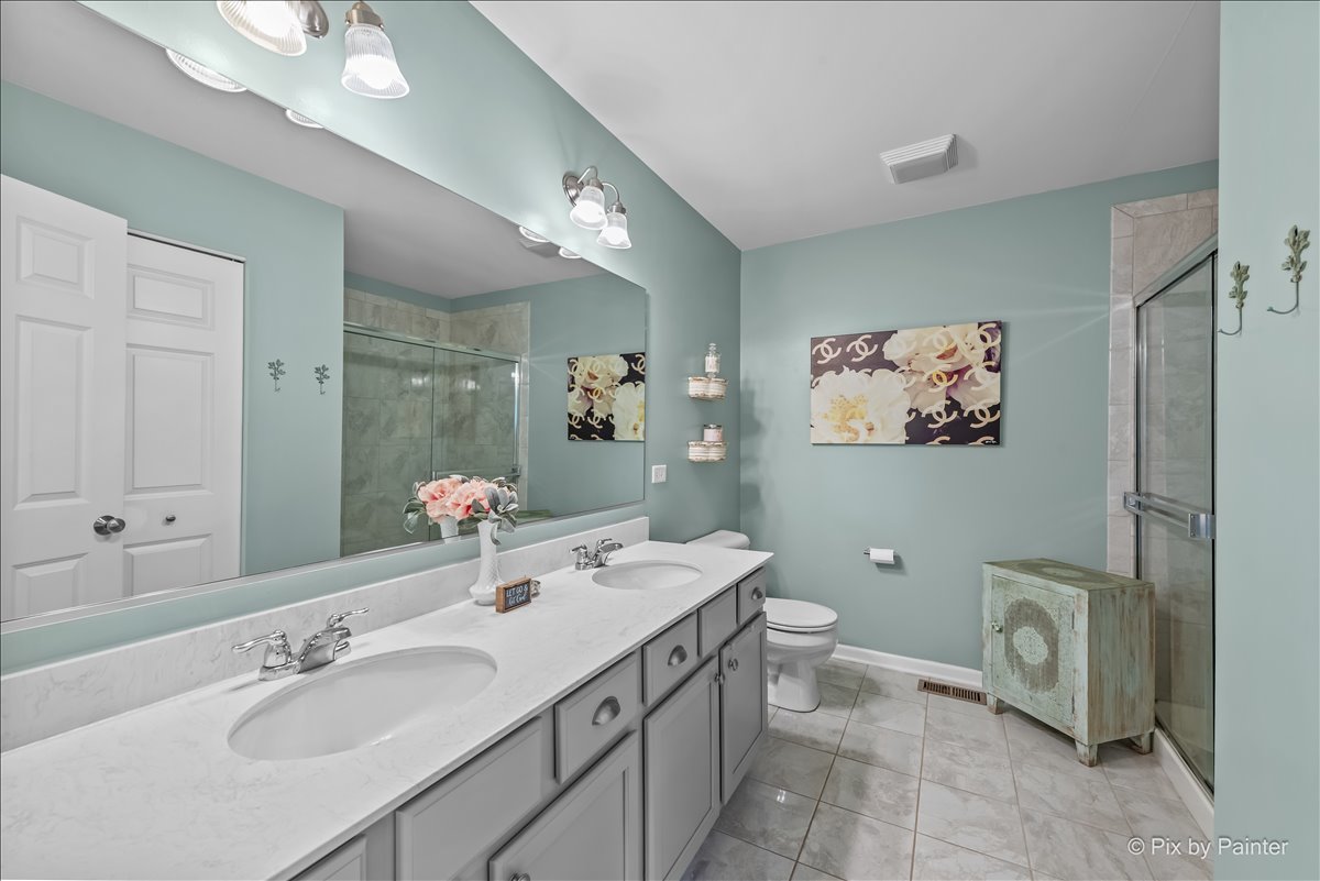 16207 West Switch Grass Road Lockport, IL 60441 - Photo 20 of 45 a bathroom with a double vanity sink mirror and toilet