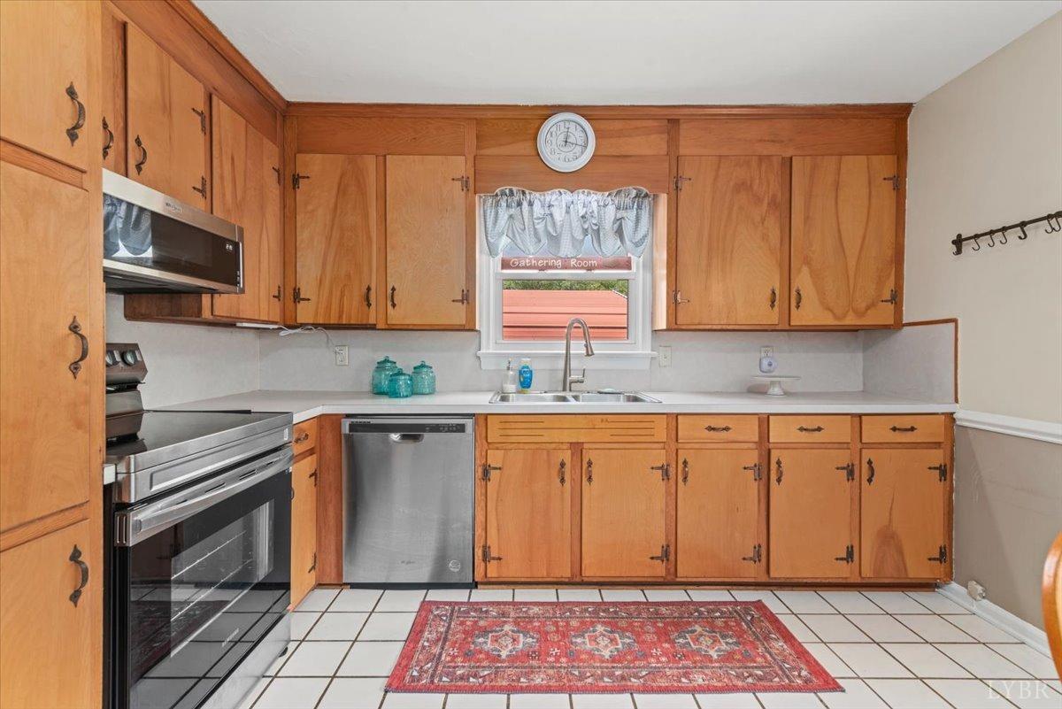 1752 Purdum Mill Road Appomattox, VA 24522 - Photo 11 of 38 a kitchen with stainless steel appliances granite countertop a stove a sink and a microwave
