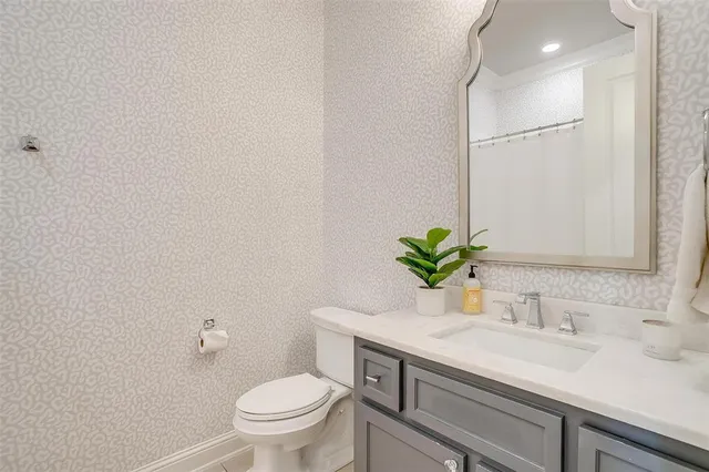 a bathroom with a granite countertop sink a toilet and a mirror