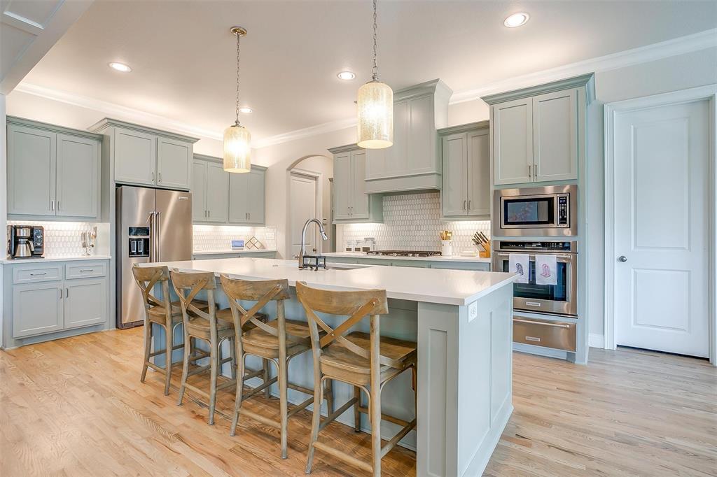 604 Rockfall Way Aledo, TX 76008 - Photo 31 of 33 a kitchen with stainless steel appliances kitchen island granite countertop a refrigerator and a stove top oven