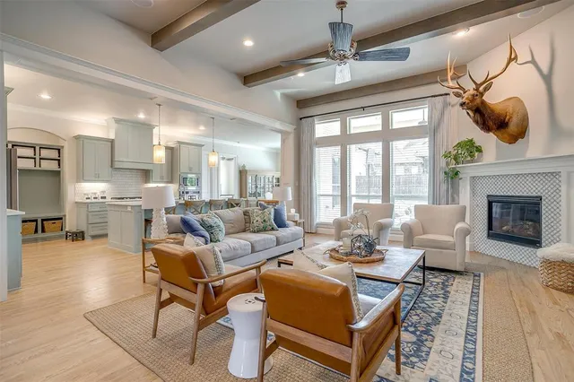 a living room with fireplace furniture and a large window