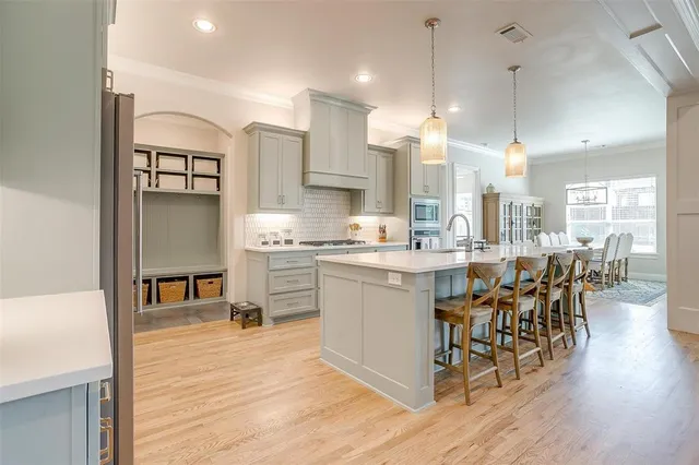 a kitchen with kitchen island granite countertop wooden floors and a view of living room