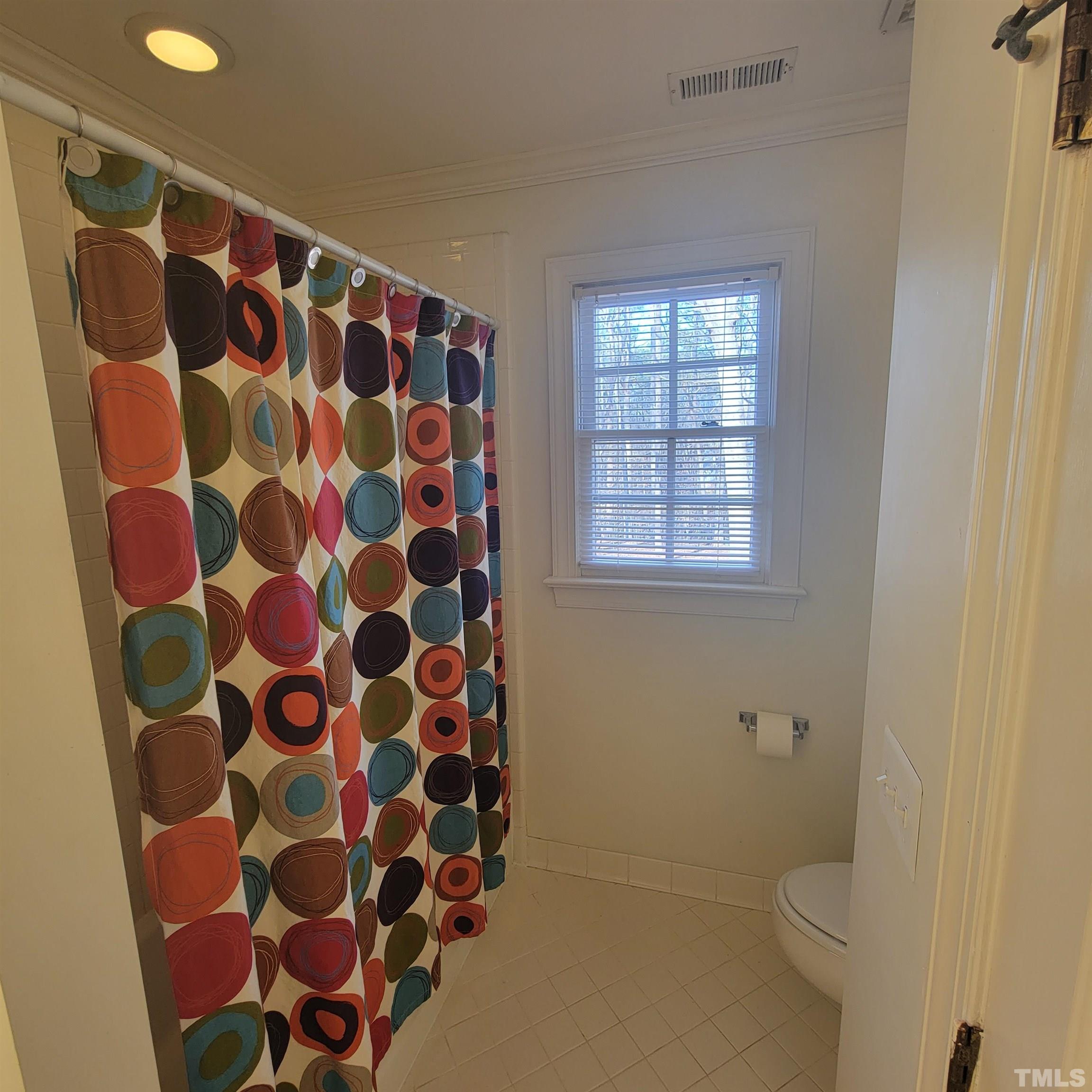 11817 Pembridge Lane Raleigh, NC 27613 - Photo 23 of 40 a bathroom with a toilet and a shower curtain