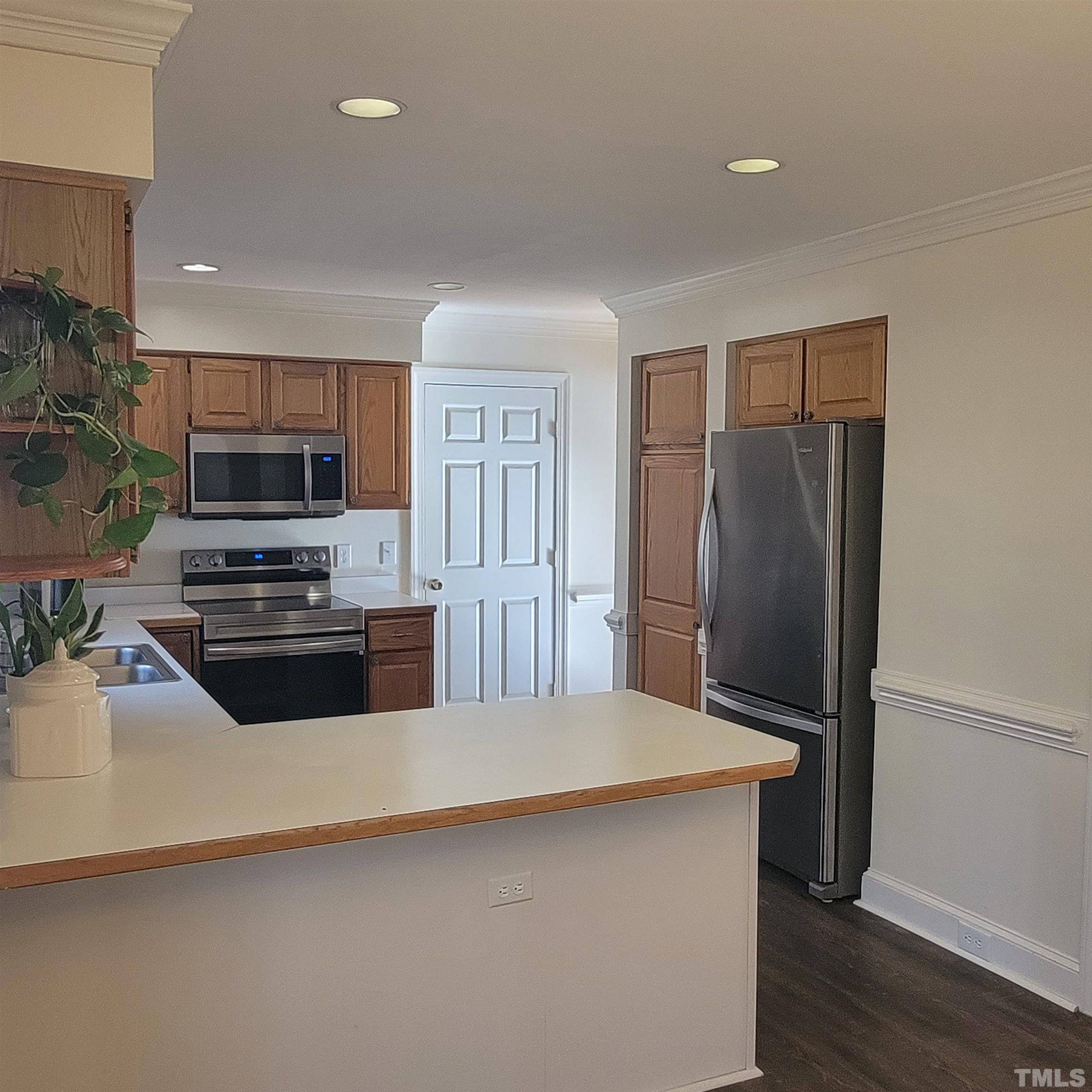 11817 Pembridge Lane Raleigh, NC 27613 - Photo 6 of 40 a kitchen with granite countertop a refrigerator and a stove top oven