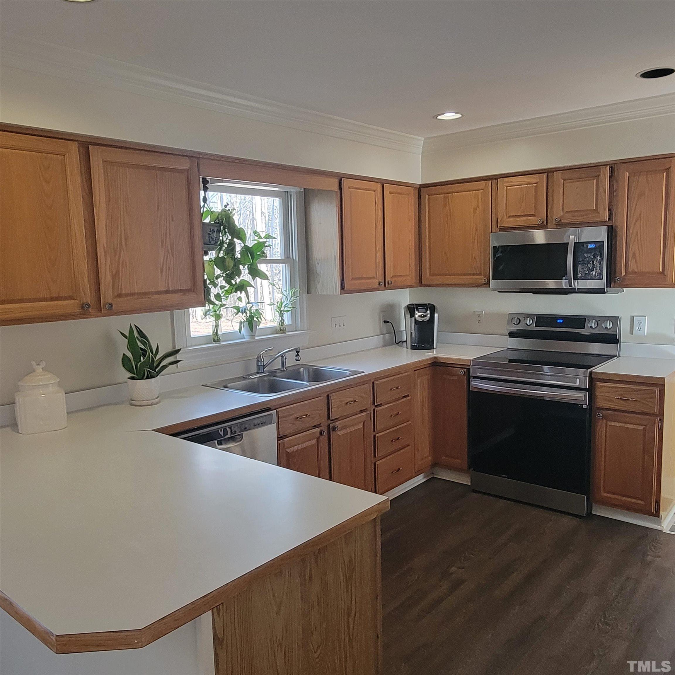 11817 Pembridge Lane Raleigh, NC 27613 - Photo 7 of 40 a kitchen with stainless steel appliances granite countertop a stove a sink and a microwave