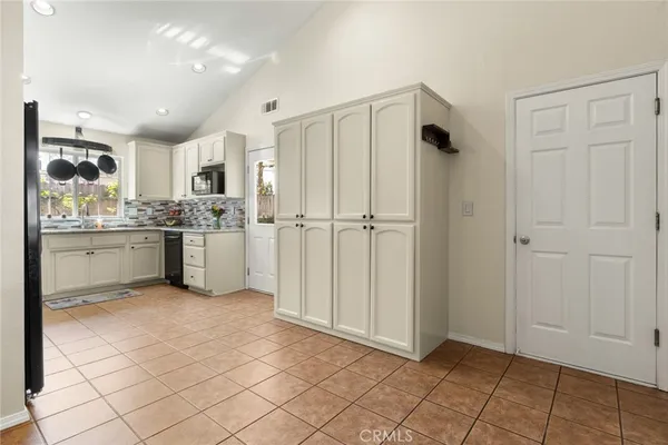 a view of kitchen with granite countertop cabinets and refrigerator