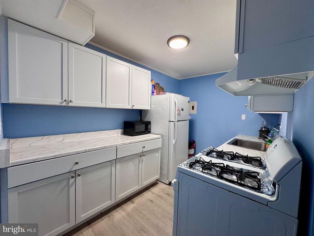 a kitchen with white cabinets and a stove top oven