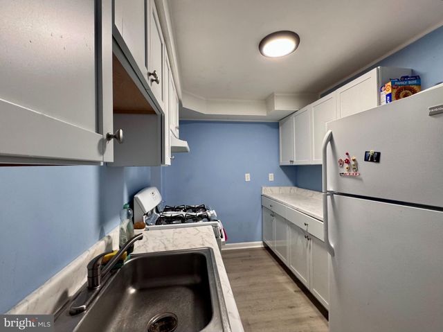 a kitchen with a refrigerator and a stove top oven