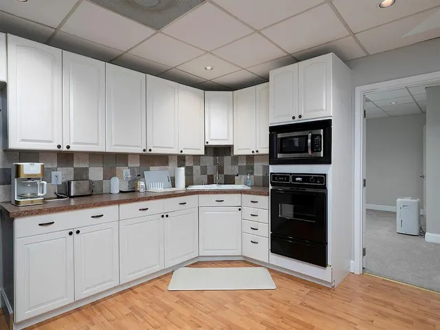 a kitchen with granite countertop a stove top oven a sink dishwasher and a refrigerator with wooden floor