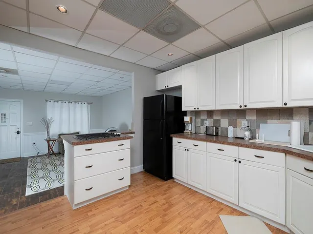 a kitchen with granite countertop white cabinets and refrigerator