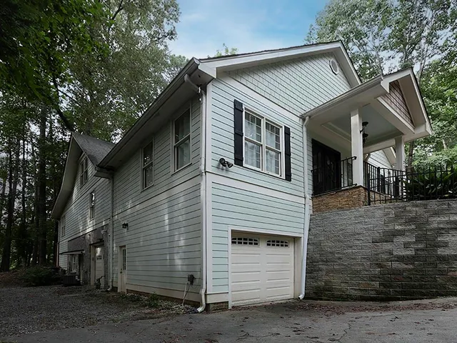 a front view of a house with a tree