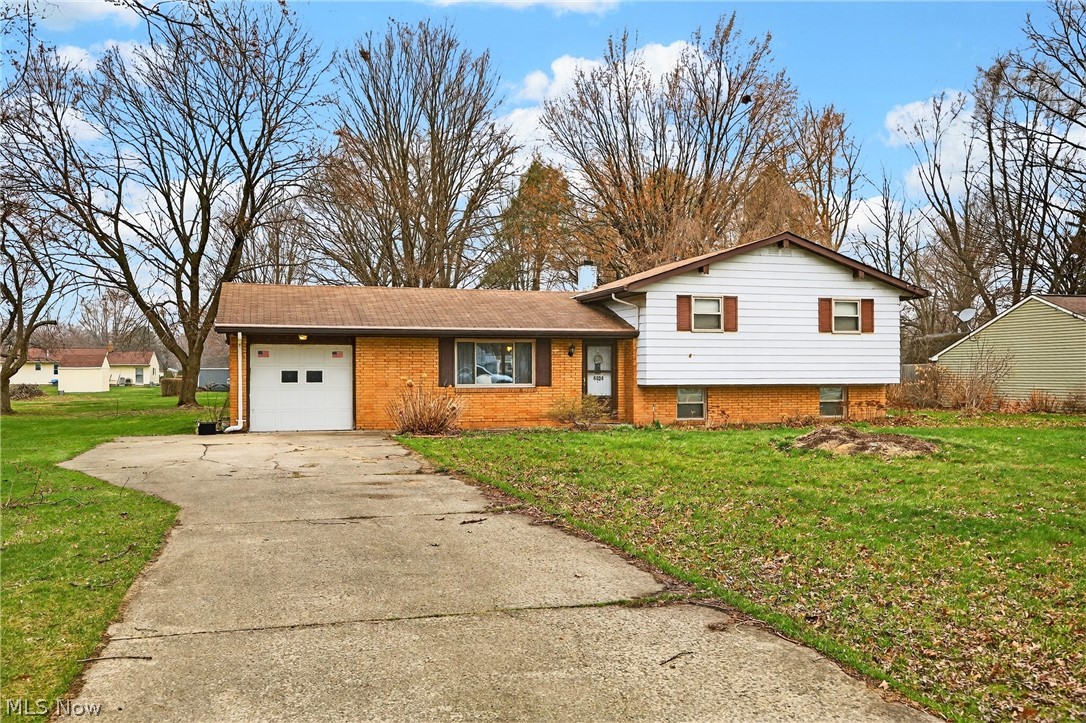 4404 Florida Street Perry, OH 44081 - Photo 2 of 24 Split level home with brick siding, a front lawn, driveway, and a garage