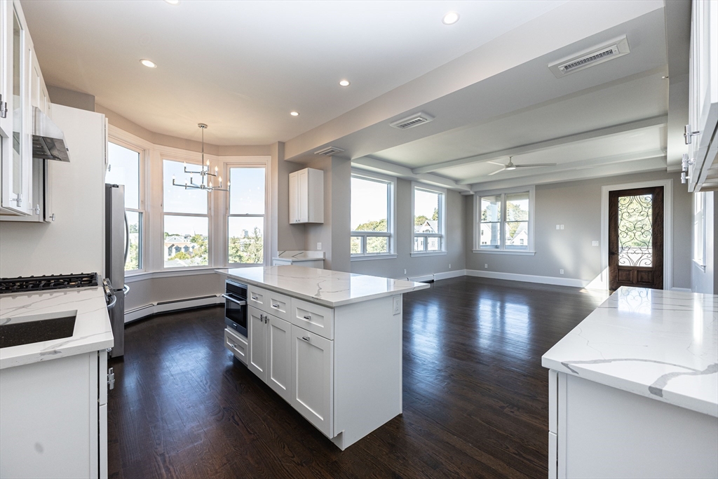 a view of a large kitchen with wooden floor and a window