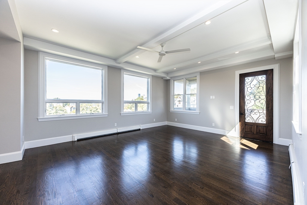 85 Regent Street, Unit 8 Boston, MA 02119 - Photo 12 of 30 a view of an empty room with wooden floor and a window