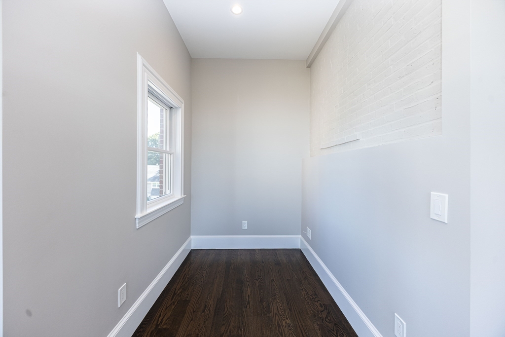 85 Regent Street, Unit 8 Boston, MA 02119 - Photo 13 of 30 an empty room with wooden floor and windows