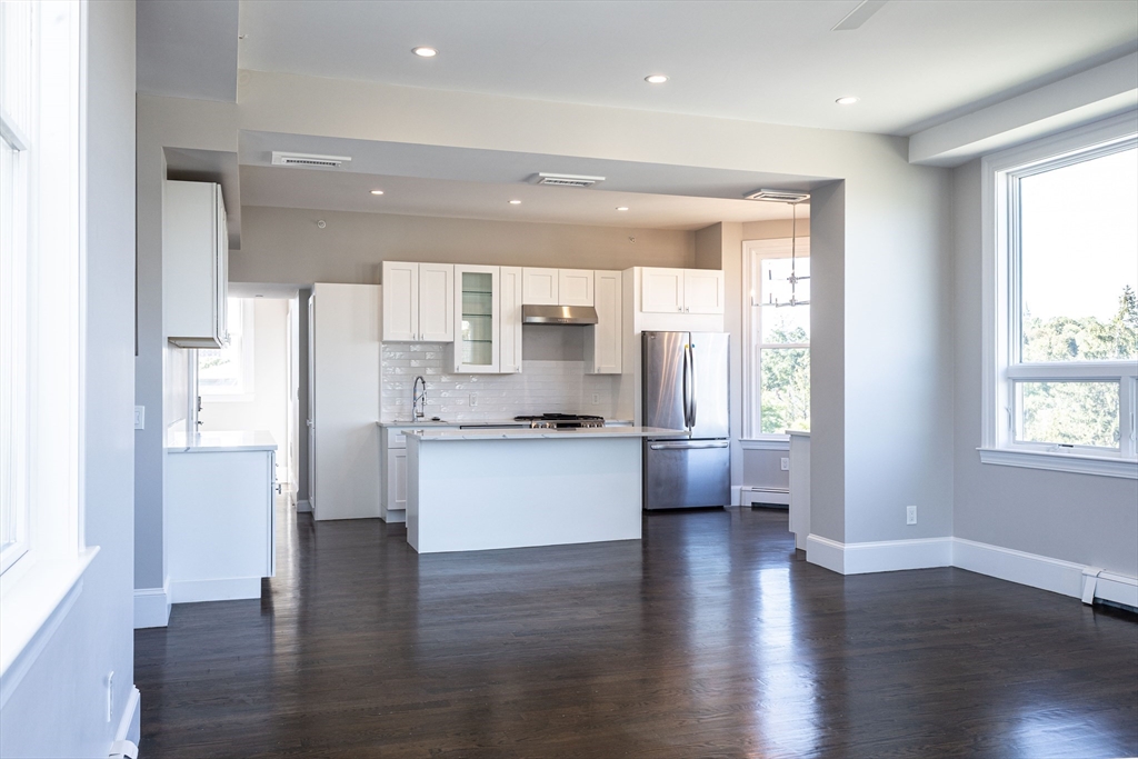 85 Regent Street, Unit 8 Boston, MA 02119 - Photo 14 of 30 a kitchen with a refrigerator and white cabinets