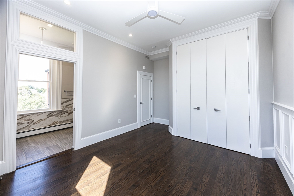 85 Regent Street, Unit 8 Boston, MA 02119 - Photo 17 of 30 an empty room with wooden floor and windows