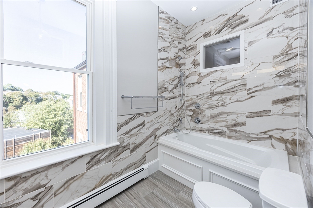 85 Regent Street, Unit 8 Boston, MA 02119 - Photo 19 of 30 a bathroom with a toilet sink and mirror