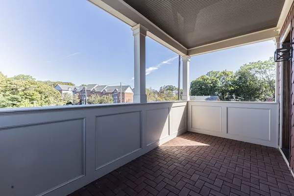 a view of a balcony with wooden floor and fence