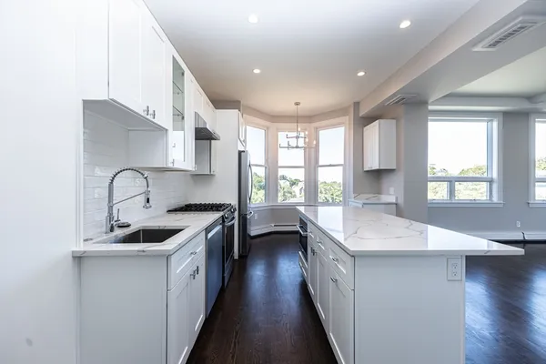 a kitchen with stainless steel appliances granite countertop a sink stove and wooden floor