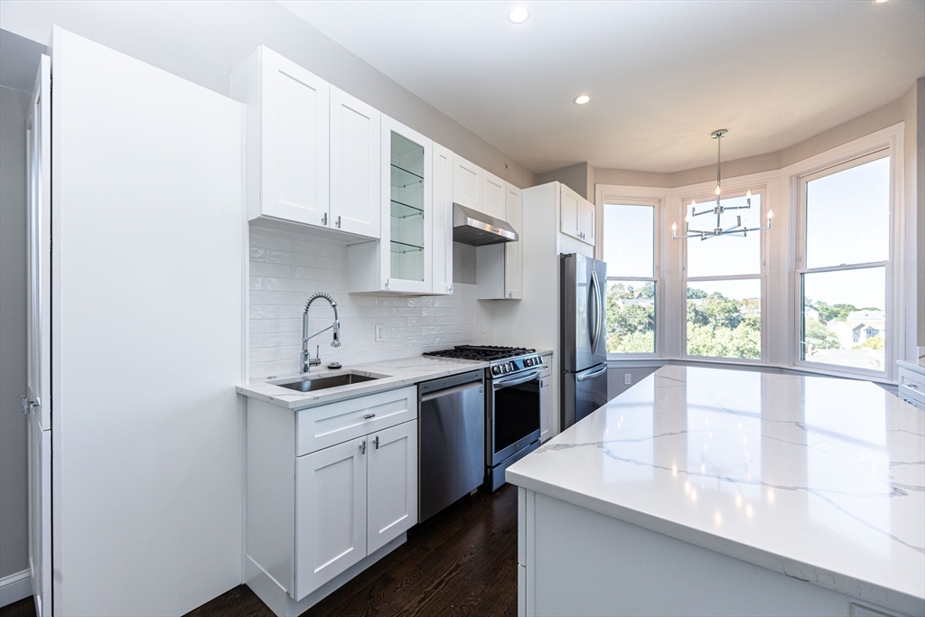 85 Regent Street, Unit 8 Boston, MA 02119 - Photo 4 of 30 a kitchen with a sink stove and cabinets