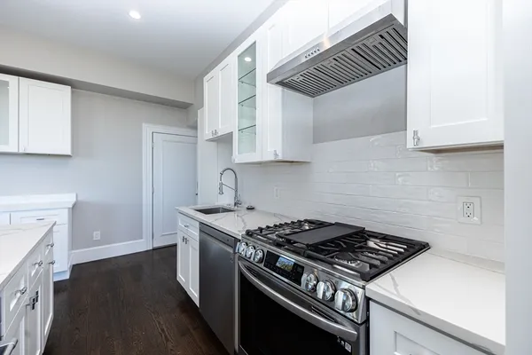 a kitchen with granite countertop a stove and a sink