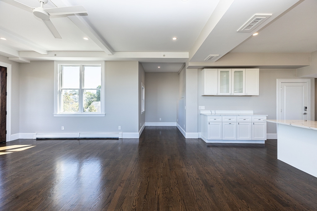 85 Regent Street, Unit 8 Boston, MA 02119 - Photo 9 of 30 a view of an empty room with wooden floor and a window